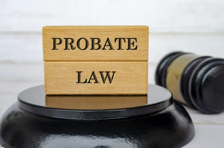 Probate Law text engraved on wooden block with blurred gavel background.
